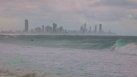 A personal watercraft rides storm generated surf with a cityscape background. Stock Footage 304717939