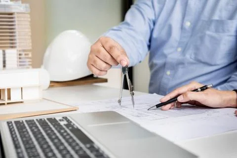 Person's engineer Hand Drawing Plan On Blue Print with architect equipment Fotos de archivo