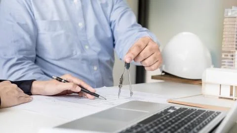 Person's engineer Hand Drawing Plan On Blue Print with architect equipment Stock Photos