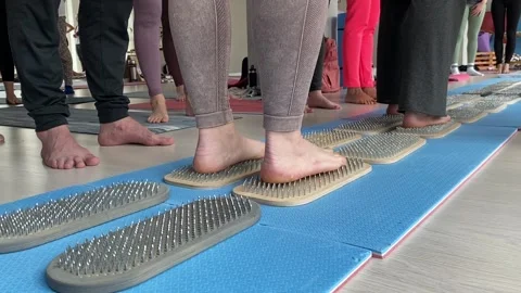 Person's feet are walking on nails during a meditation class. Stock Footage 305973227