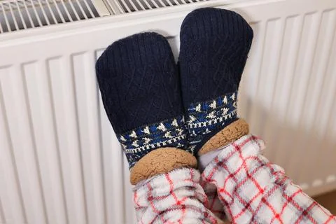 A person's feet in cozy, patterned navy knit slipper socks and plaid pajama.. Stock Photos