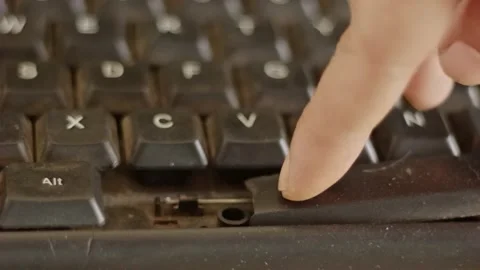 A person's finger repeatedly pressing a broken, snapped, and dusty computer.. Stock Footage 324821471