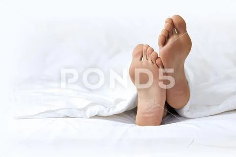 Person's foot in bed Stock Photos