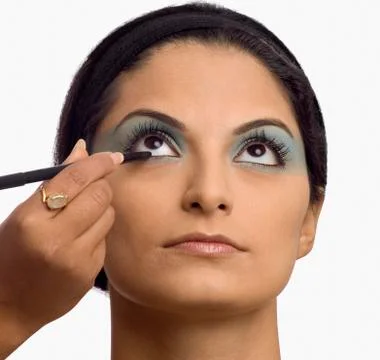 Person's hand applying eye liner on a young woman Fotos Stock