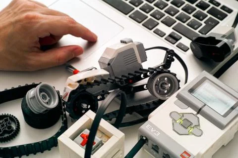 Persons hand coding  LEGO MINDSTORMS EV3 robot blocks on laptop. Stock Photos