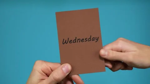 A person's hand gives notes with the days of the week to another Видео 294101782