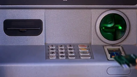 A person's hand inserting a credit card into an ATM, dialing password, and Stock Footage 82984197