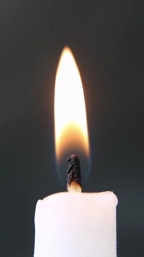 A person's hand lights a candle with a match. Close-up of a candle flame. Stock Footage 237969116