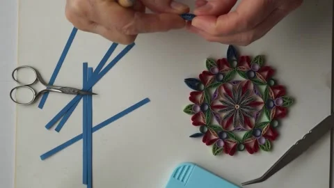 Persons hand making an ornament for a quilling figurine made out of paper Stock Footage