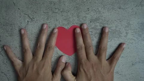 A person's hand placing a heart shaped on a wall Stock Footage 296315037