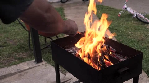 Persons hand preparing a fire in the barbecue grill in the backyard Vidéo 285192151