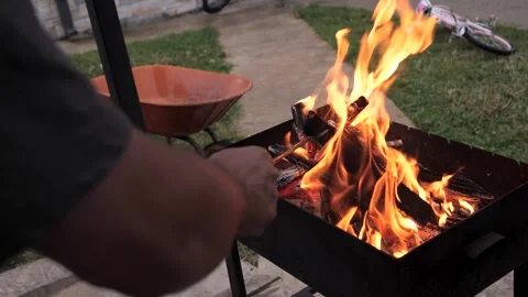 Persons hand preparing a fire in the barbecue grill in the backyard Stock-Footage 289240055