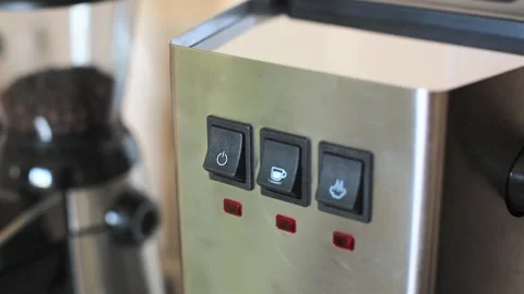 Person's hand presses a finger on the button for turning on an espresso machine. Stock Footage 169814676