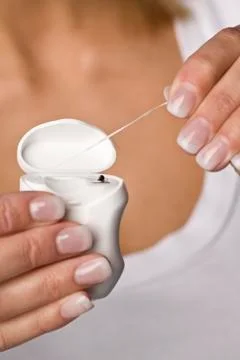 Person's hand pulling out dental floss, close-up Stock Photos