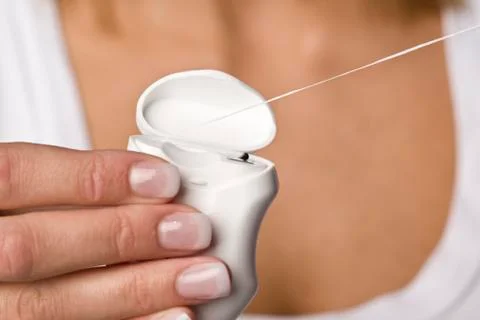 Person's hand pulling out dental floss, close-up Stock Photos