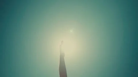 Person's hand stretches toward a bright light Stock Footage 336976036