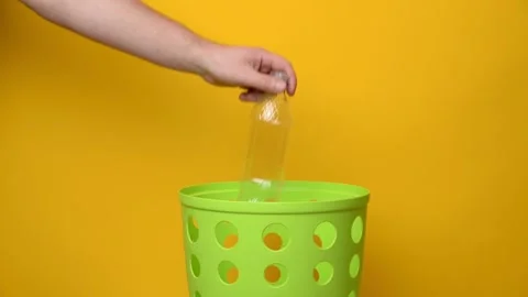A person’s hand throws a plastic bottle into a garbage bucket Stock Footage 194566388