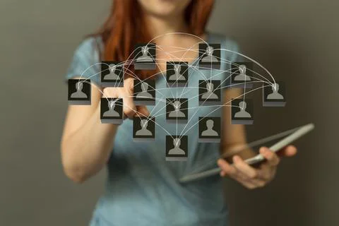 Person's hand touching the 3D rendered people silhouettes in the network team Fotos de archivo