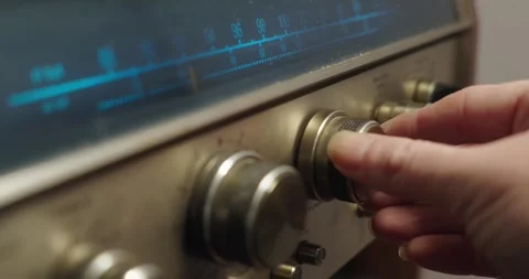 A person’s hand , turning  knobs to adjust the station on vintage radio 動画素材 261145913