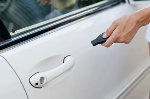 Person's hand unlocking the car with remote control Stock Photos