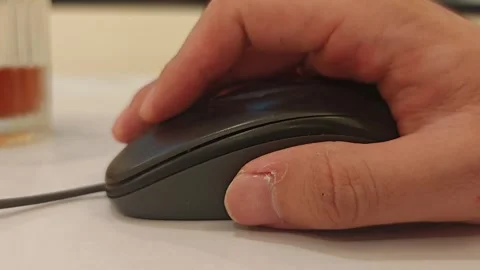 A person's hand using a black computer mouse, clicking and scrolling Stock Footage 347729581