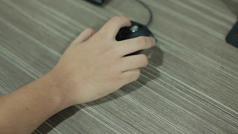PERSON'S HAND USING COMPUTER MOUSE ON TABLE Stock Footage 107028995