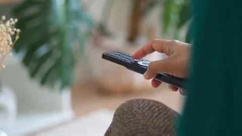 Person's hand using remote control to change channel on television close up.. Stock-Footage 332908232
