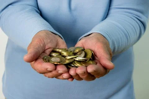 A persons hands are open, holding a pile of euro coins Stock Photos