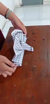 A person's hands are practicing the art of folding cloth towels or napkins Stock Photos