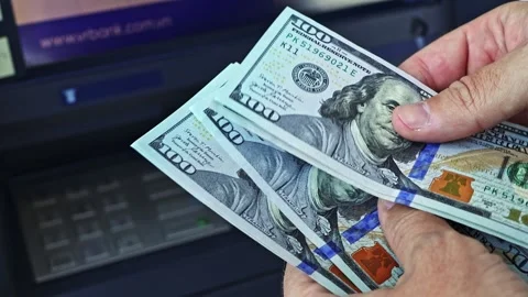 Person's hands count 100 dollar banknotes near ATM machine Stock Footage 329671413