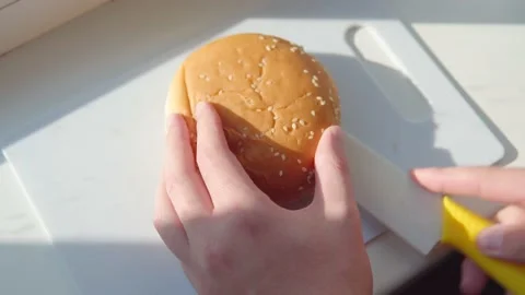 Person's hands cut the burger bun with a sharp knife. Stock Footage 161134562