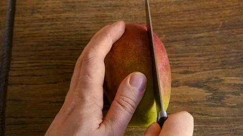 Person's hands cuts mango Stock Footage 147550440