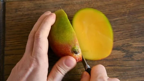 Person's hands cuts mango Stock Footage 147550457