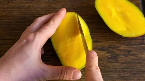 Person's hands cuts mango Stock Footage 147550495