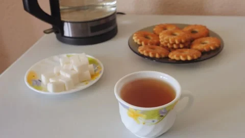 A persons hands dip a tea bag into a cup of hot water on a table Stock Footage 319577737