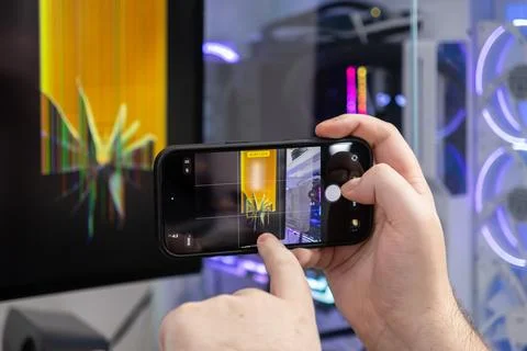 Person's hands film a broken computer monitor with a smartphone, documentin.. Foto stock