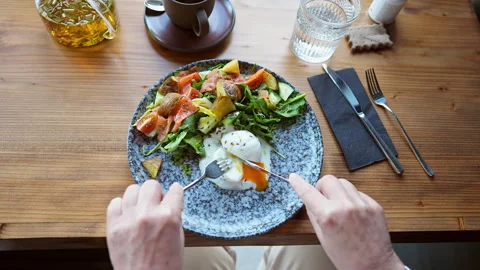 A persons hands hold a fork and knife over breakfast. Stock Footage 311241753