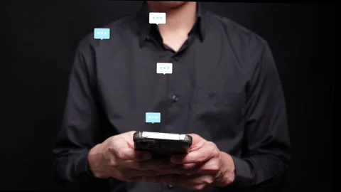 A person's hands hold a smartphone, with translucent speech bubbles layered abov Vídeos de archivo 347996179