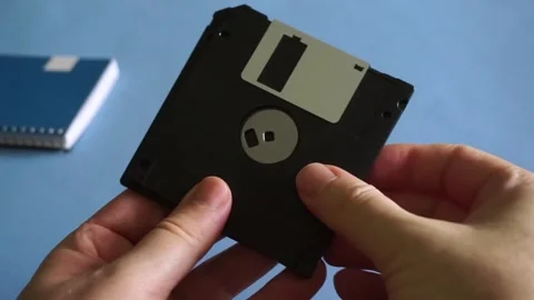 Person's hands holding and showing old floppy disks, a vintage data storage Stock Footage 340118439