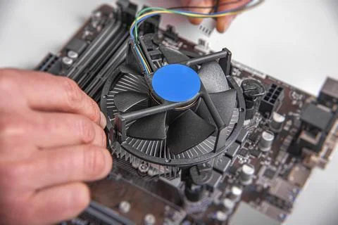 A persons hands installing a cooling fan onto a CPU socket. Stock Photos