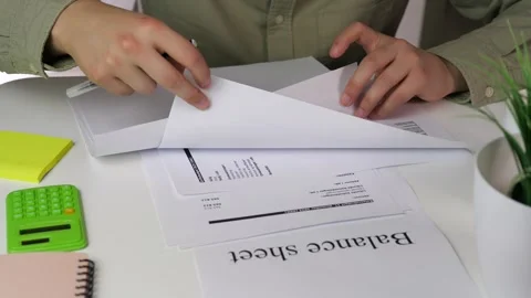 A persons hands interact with annotated financial statements, highlighting Stock Footage 316220255