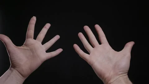 Persons Hands Raised Up with Open Palms on a Black Background Stock Footage 329913929