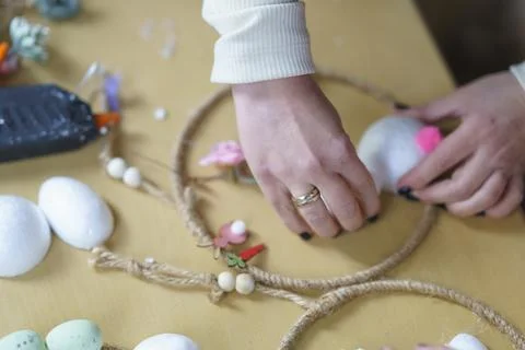 A person's hands with rings on a table making  children's crafts Foto stock