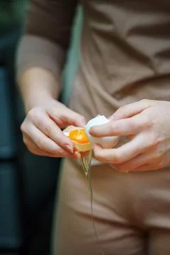 Person's hands skillfully separating egg white from yolk using eggshell halve Stock Photos