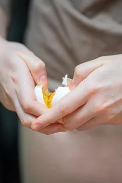 Person's hands skillfully separating egg white from yolk using eggshell hal.. Foto stock