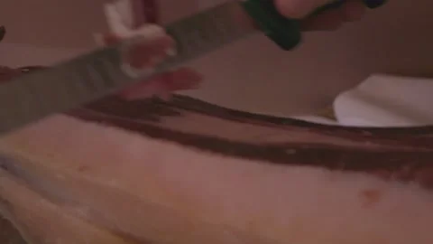 Person's hands slicing thin jamon serrano ham Stock Footage 337221397
