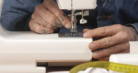Person's hands threading a modern sewing machine needle 写真素材