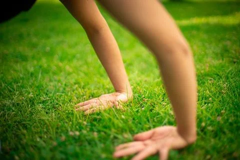 Person's hands touching green grass, feeling nature Stock Photos