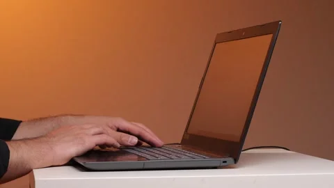 Person's hands typing on a laptop keyboard, representing concepts of remote Stock Footage 347238010