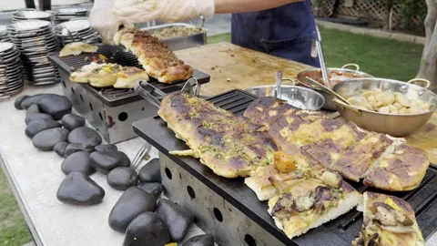 Person's hands in white gloves cut stuffed pizza and focaccia by special knife Stock Footage 245339931